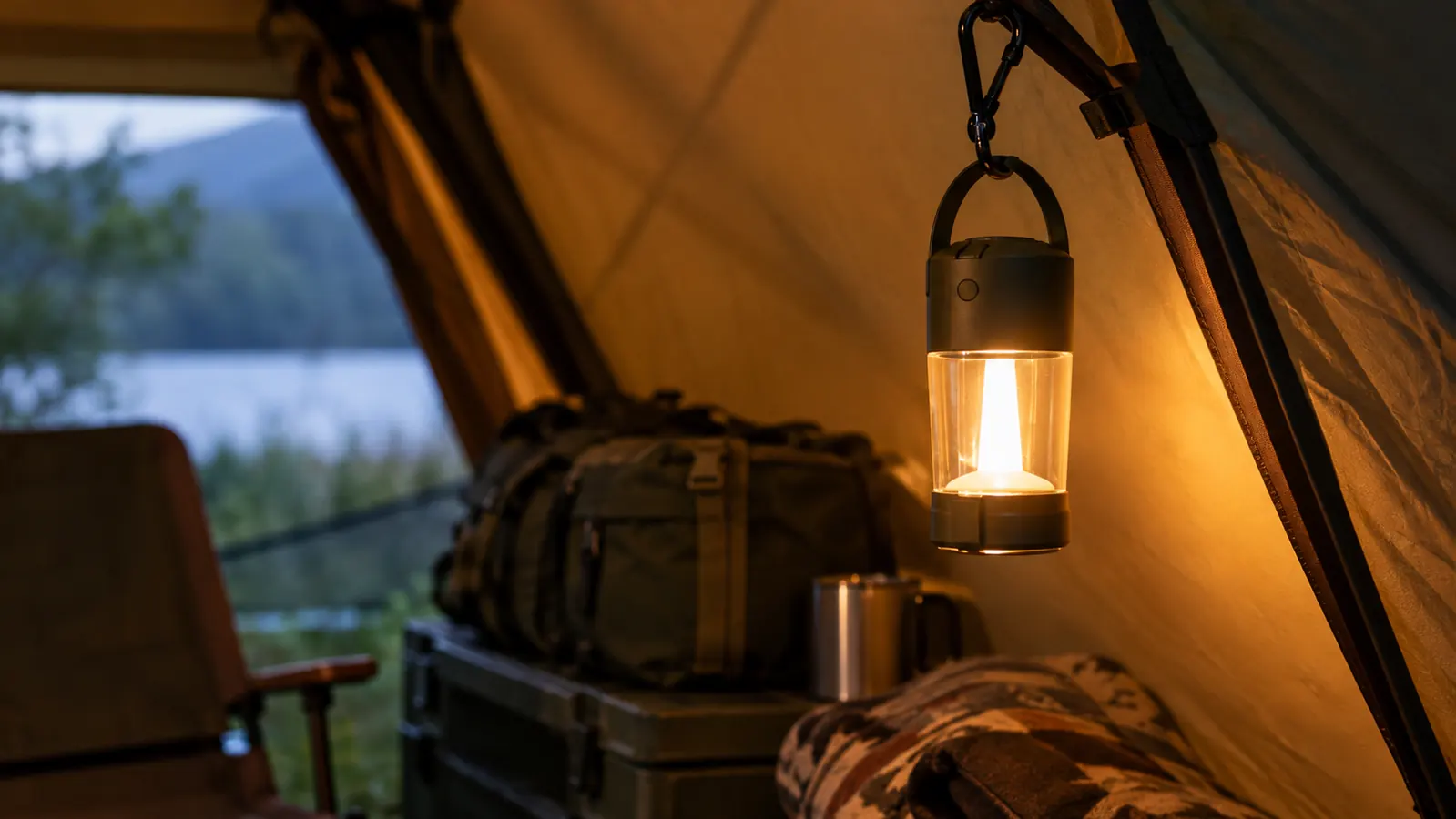 A rechargeable lantern hanging from a hook inside a tent, casting a soft glow